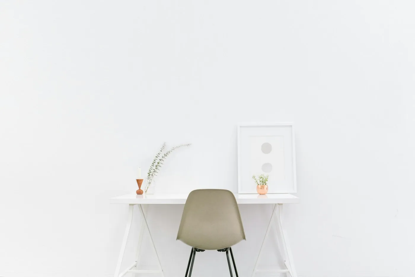 Minimal white desk and chair with small decorative objects