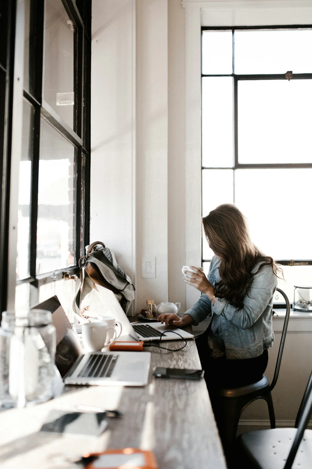 Woman wearing a blue denim jacket while working at a laptop